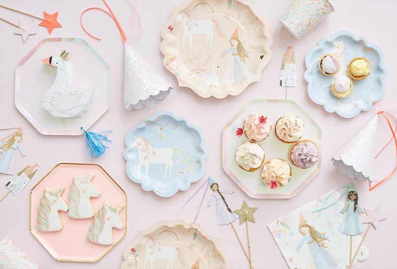 Pastel princess party spread with unicorn toppers decorative plates and cupcakes