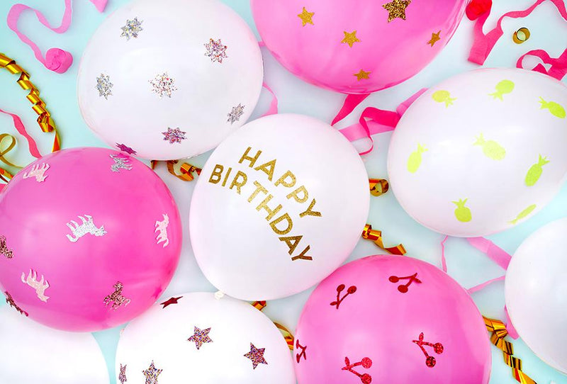 White and pink birthday balloons with gold Happy Birthday lettering and star confetti