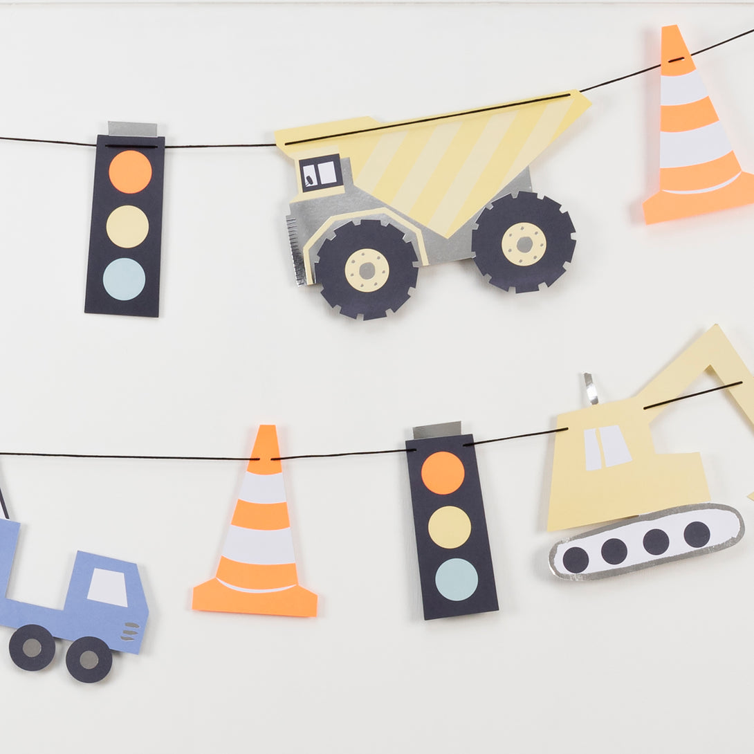 Our construction party supplies include paper plates, a 3D garland, cups, napkins, hats and a cupcake kit.