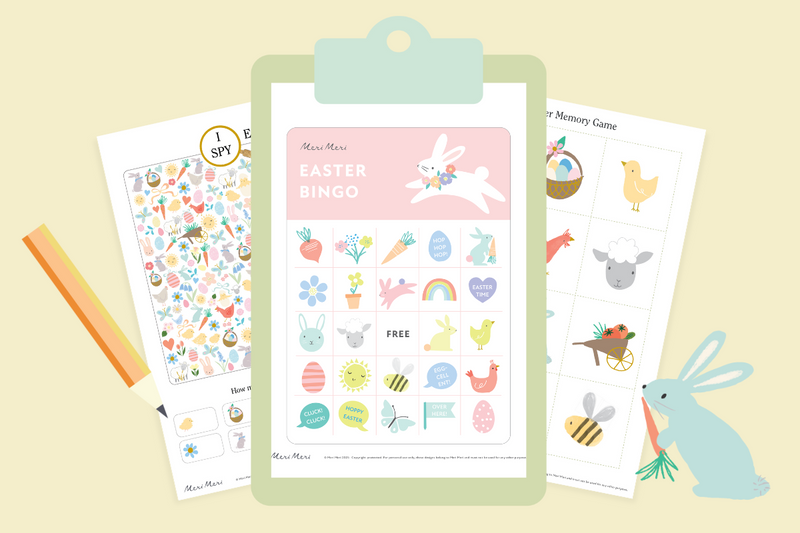  clipboard holding an Easter bingo card with illustrations of rabbits, eggs, and carrots, alongside an "I Spy" activity sheet and cards for a memory game.