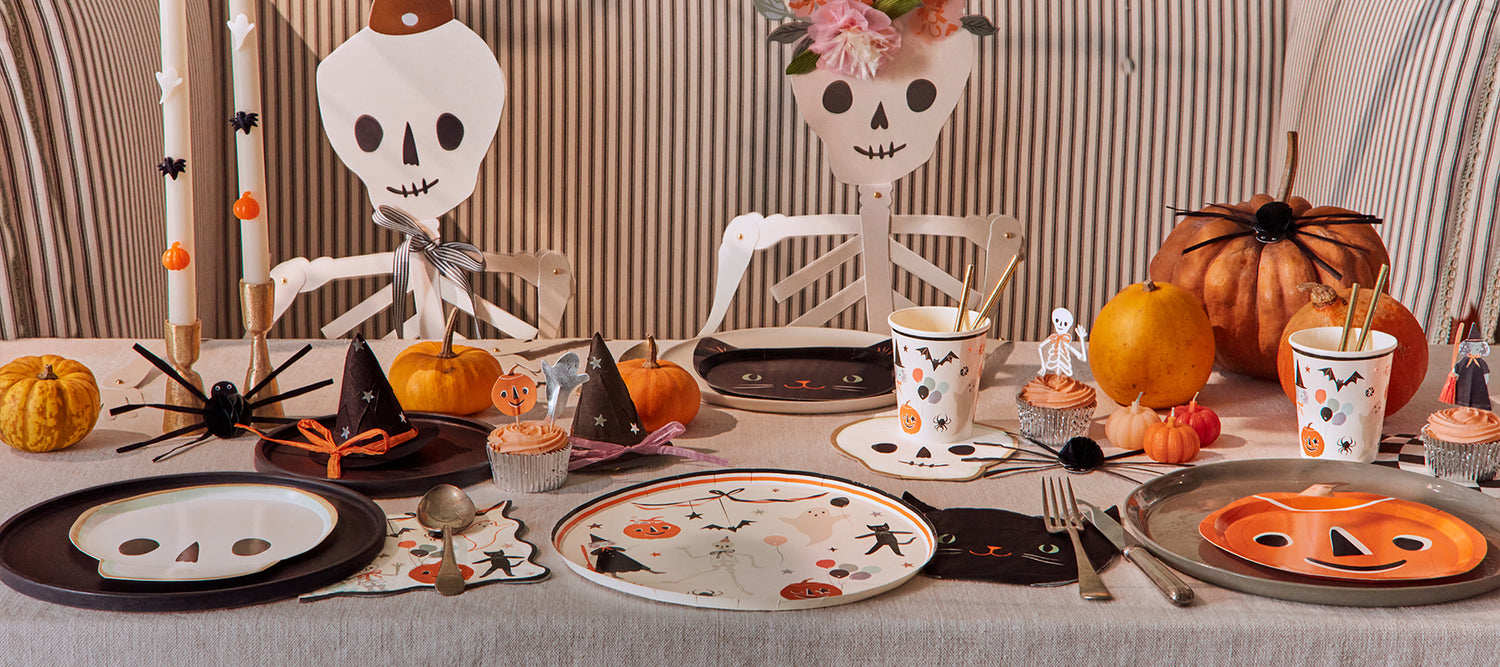 A Halloween party table is decorated with Meri Meri Halloween plates, cups and napkins with vintage-inspired designs. 