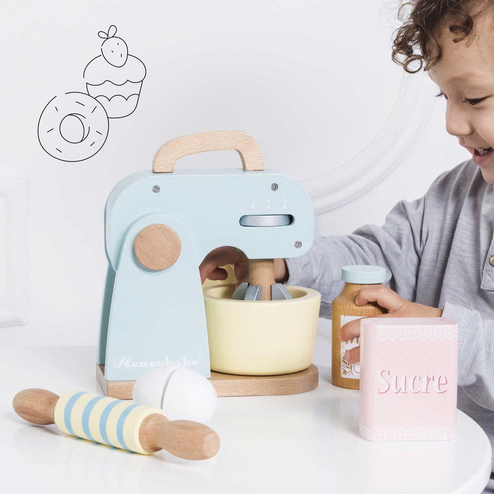 Boy pretending to bake with the wooden mixer set