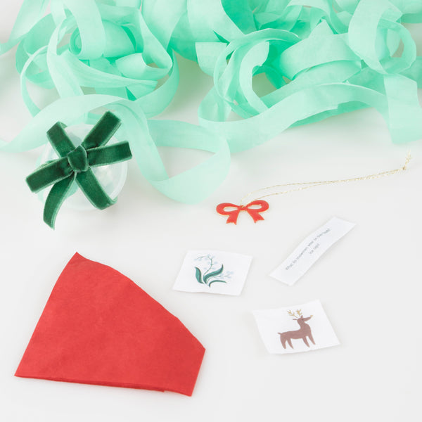 Our stylish surprise bows feature big red velvet bows and contain a red party hat, jokes, stickers and a bow enamel charm. Image2