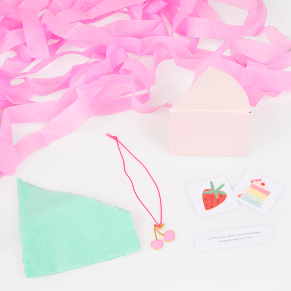 Our party favors come in the shape of cake slices, open to reveal stickers, a joke, a party  hat and an enamel cherry charm. Image3