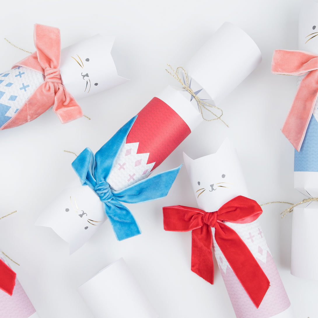 Our Christmas cat crackers look amazing, with velvet bows, and contain wooden cat brooch pins, gold party hats and funny jokes.