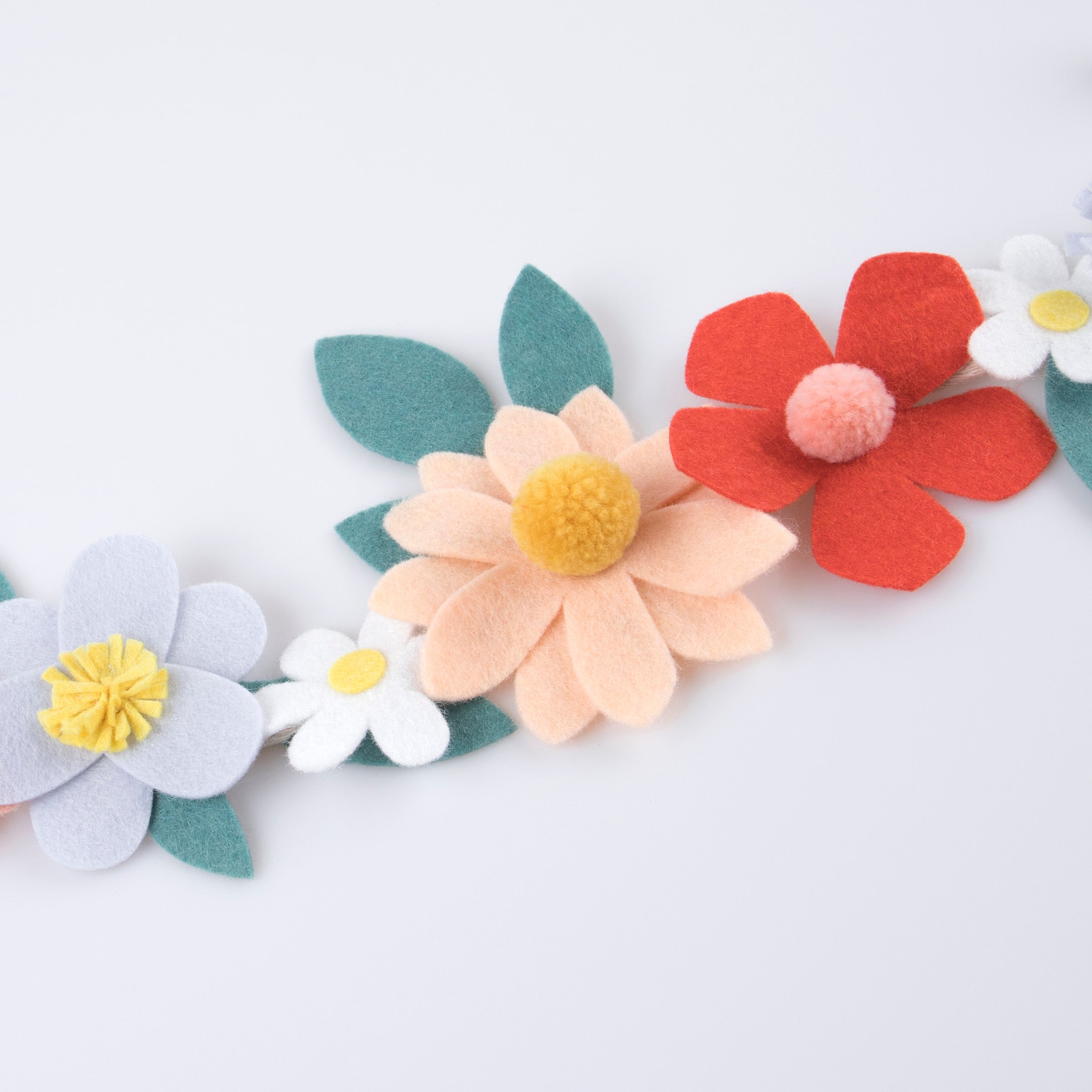 Our special party garland is crafted from felt, with flowers with pompom centers.