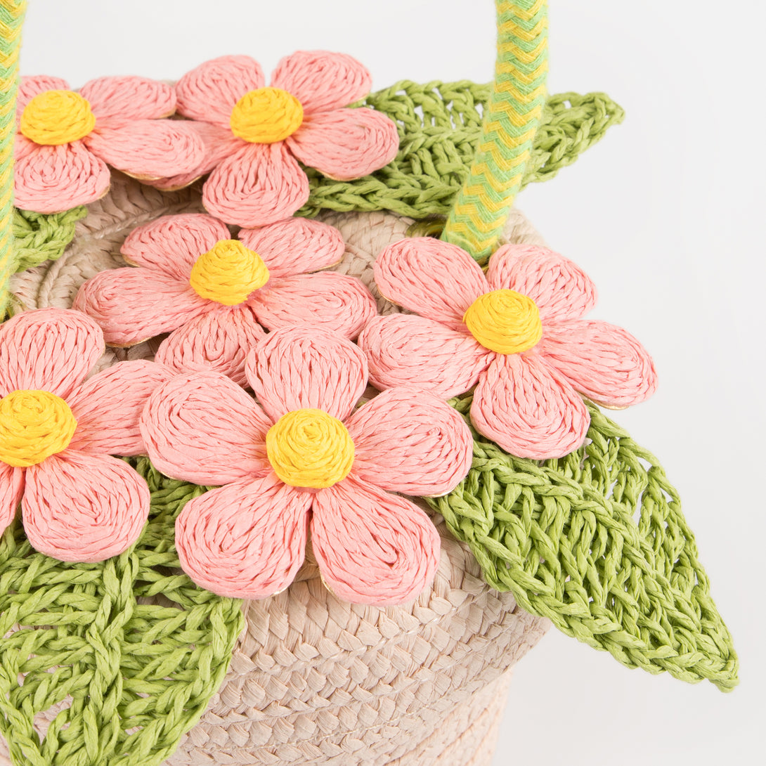 Our woven paper pink basket bag features paper flowers and leaves, a cord handle and a calico lining.