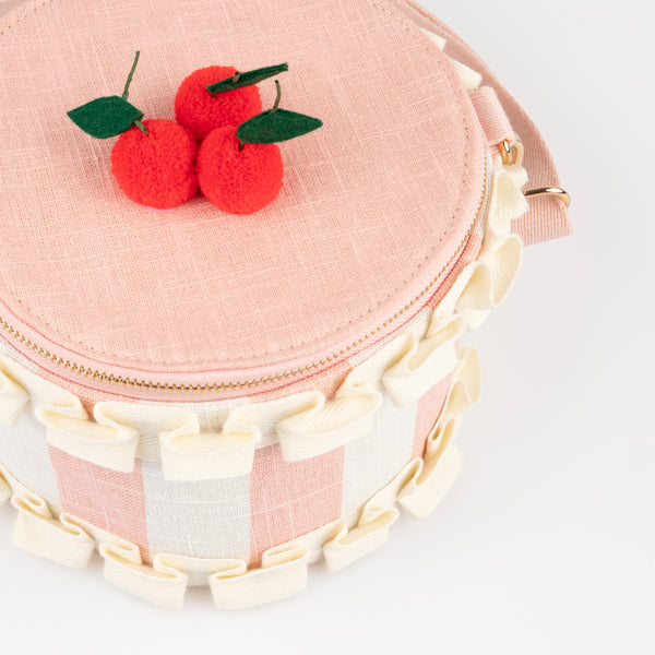 Our pink fabric bag, crafted to look like a cake, features fun pompom cherries, felt leaves, a ruffled ribbon and a long webbing handle. Image4