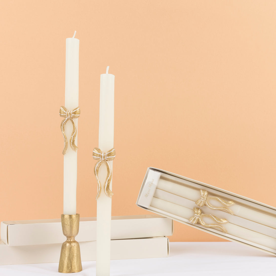 Our golden Christmas host gift set includes two table candles, with gold stripy bow details, and a pack of paper napkins with gold bow designs. Image3