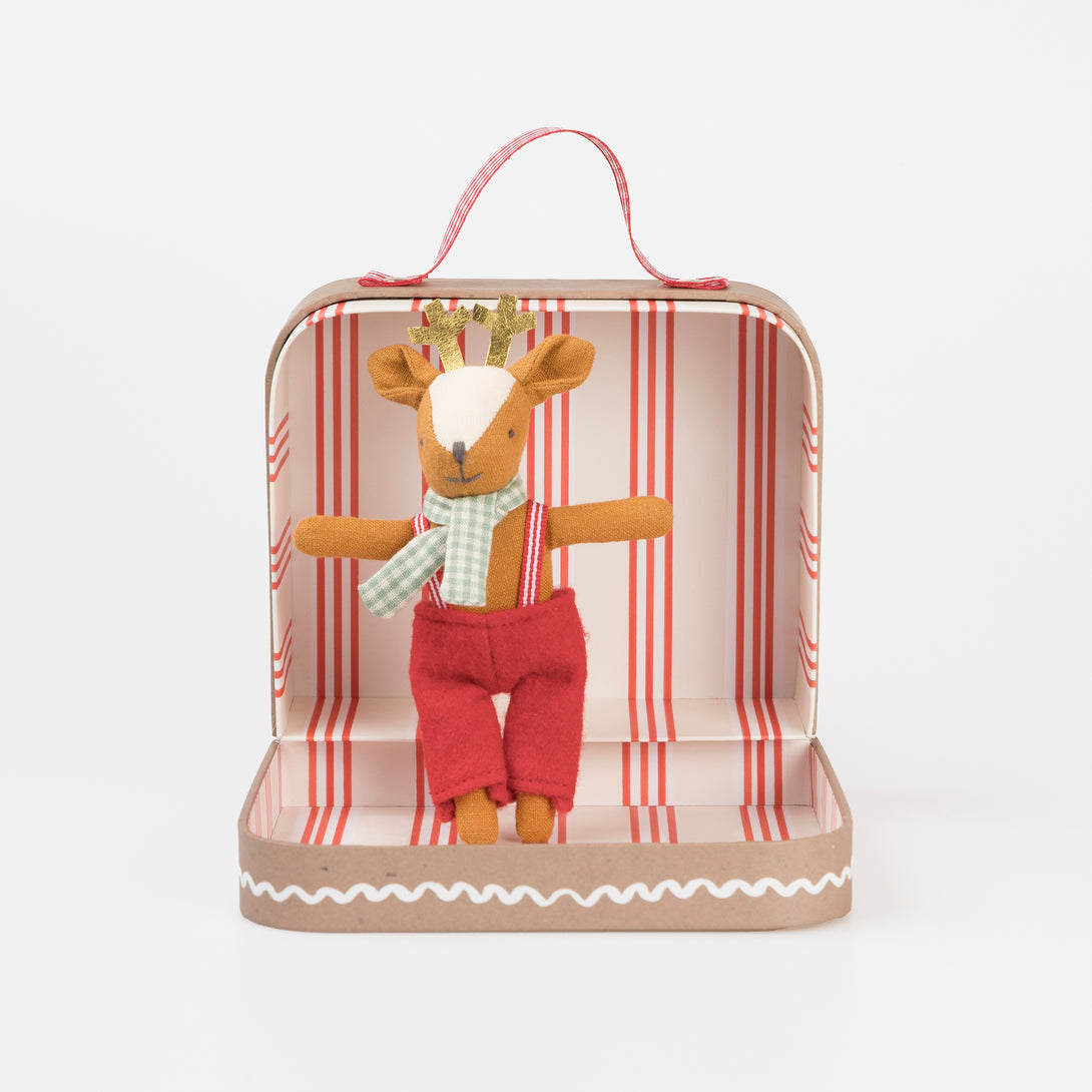 Our Christmas doll set includes a mini fabric reindeer doll in a laminated mini suitcase designed to look like a gingerbread house.