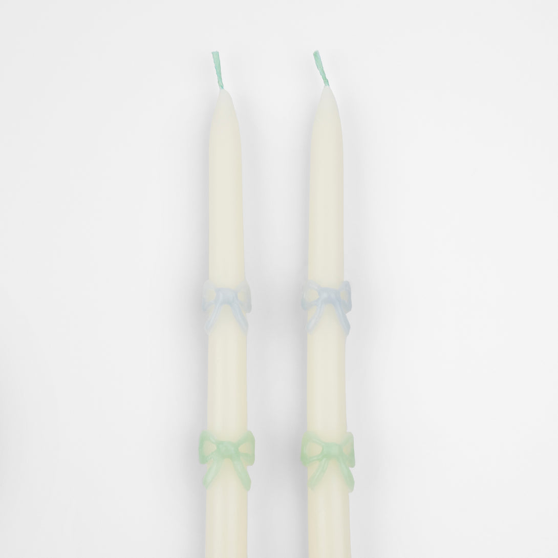 Our party candles, crafted in a tapered shape with embossed and handpainted pastel bows, have mint green wicks. Image3