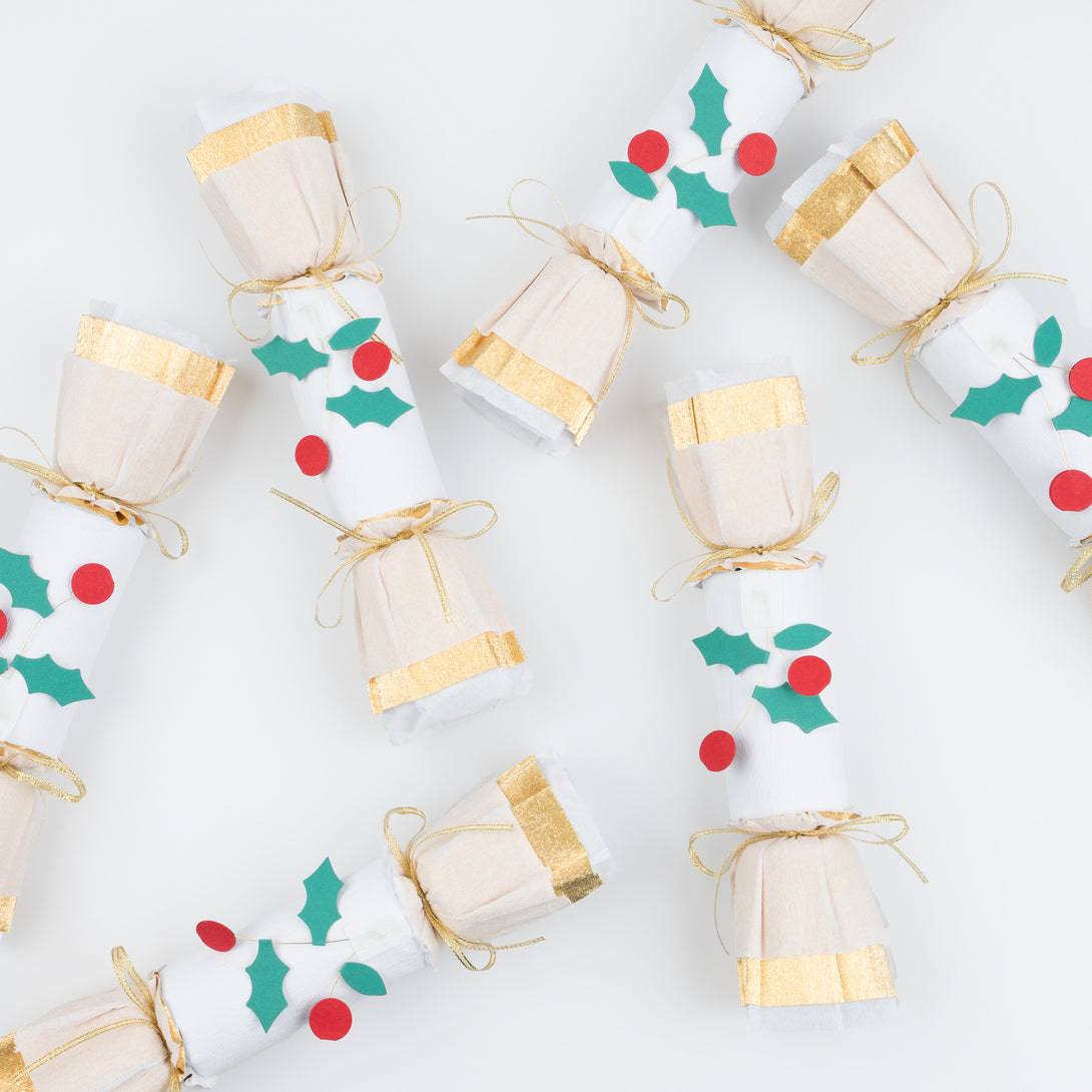 Our luxury holly Christmas crackers feature gold crepe paper and bows, and each contain a gold party hat, joke and a Christmas brooch.