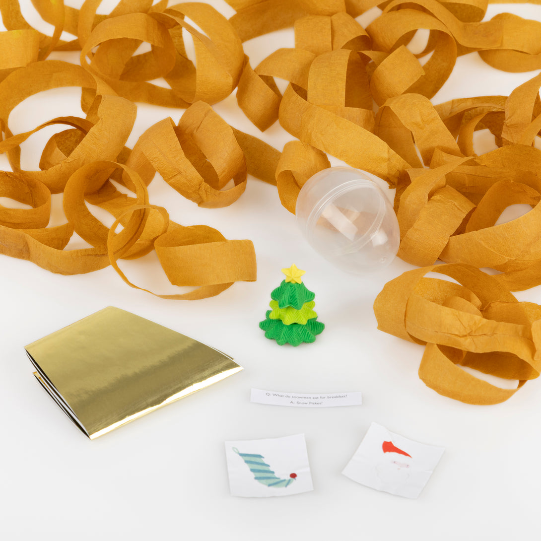 Our surprise balls, in the shape of Santa, a snowman and a reindeer, contain a gold party hat, 2 stickers, a joke and a fun eraser. Image2