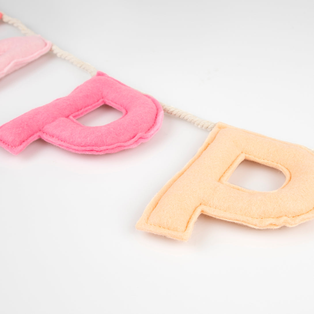 Our happy birthday garland has felt letters in peach and pink tones, ideal to reuse year after year.