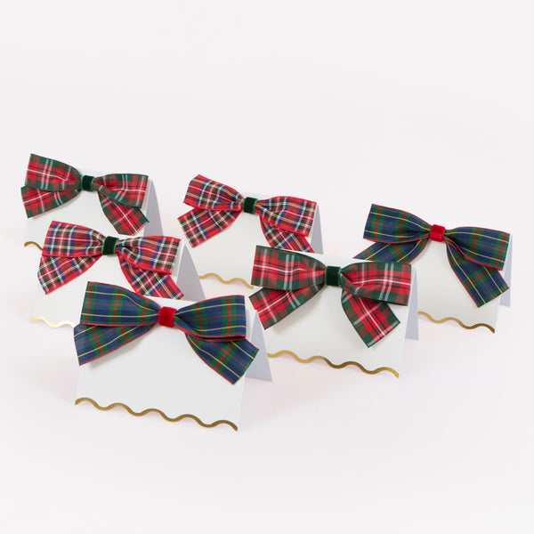 Our Christmas place cards feature scalloped edges with shiny gold foil details and are beautifully topped with plaid and velvet ribbon bows. Image1