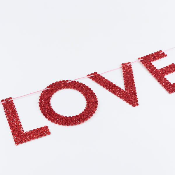 Our Valentine's Day garland features chunky pink and red glitter fabric letters to spell out the word love three times, vibrant and stylish. Image2