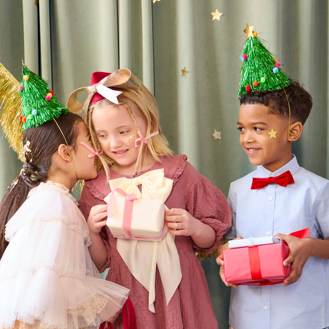 Wear our Christmas paper hats, in the shape of pompom-adorned Christmas trees with tinsel and gold stars, for lots of family fun. Image1