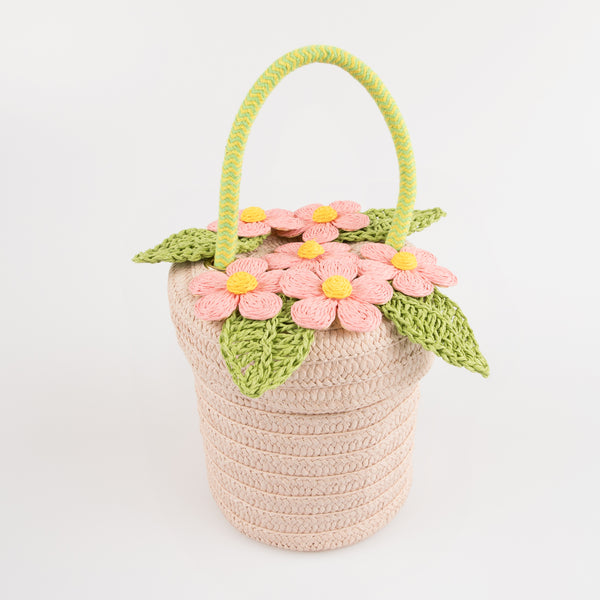 Our woven paper pink basket bag features paper flowers and leaves, a cord handle and a calico lining.