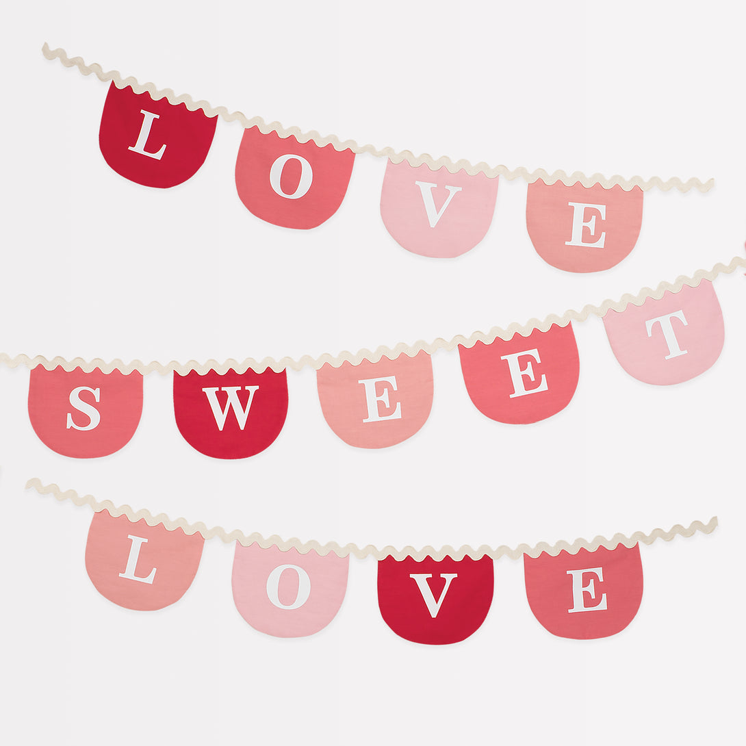 Our Valentine's decoration, a fabric garland, has scalloped pennants in red and pink with a romantic message.