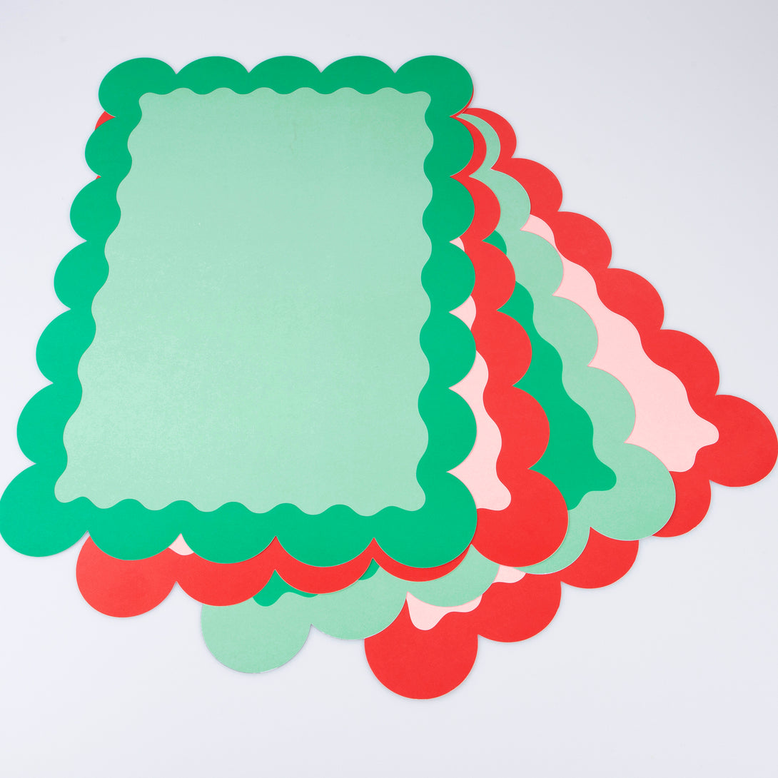 Our paper placemats are crafted in Christmas colors of red and green, with a modern pop of pink, and stylish scalloped edges.