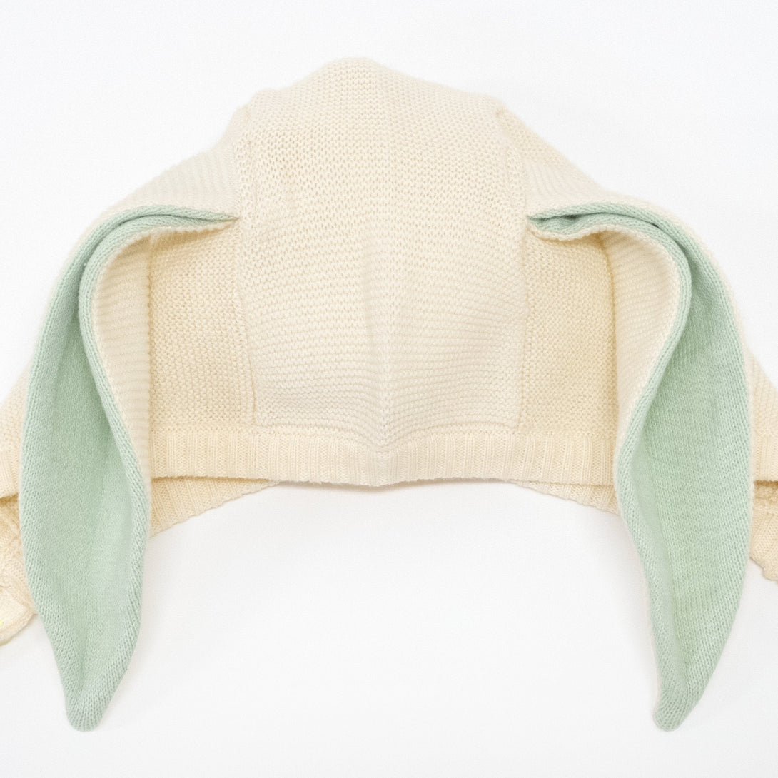 This delightful bunny baby bonnet is crafted from knitted organic cotton, with mint detail on the ears, and fastens with ivory colored buttons.