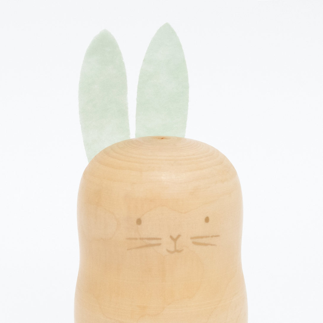 These stacking bunnies are crafted from wood, with gold features, and felt ears and tails.