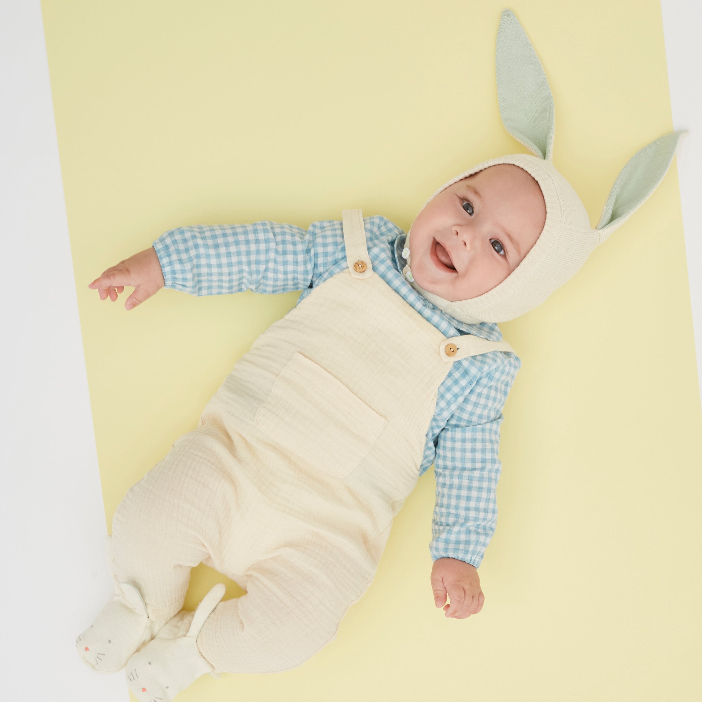 This organic cotton bunny bonnet has a shimmering peach inner on the ears, and an ivory colored button fastening.
