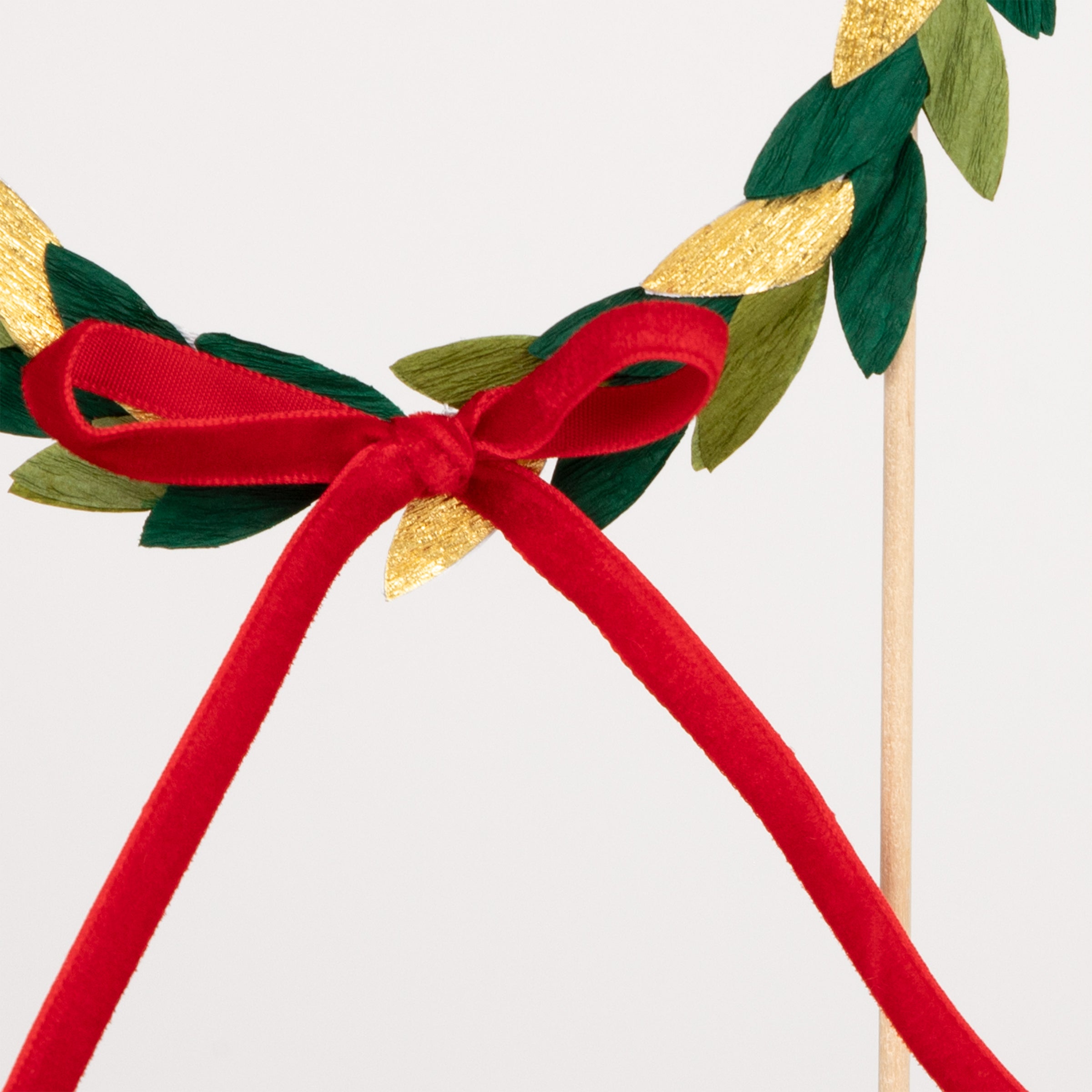 Our Christmas cake topper, a festive wreath with paper leaves and a velvet bow, is the perfect Christmas cake decoration.