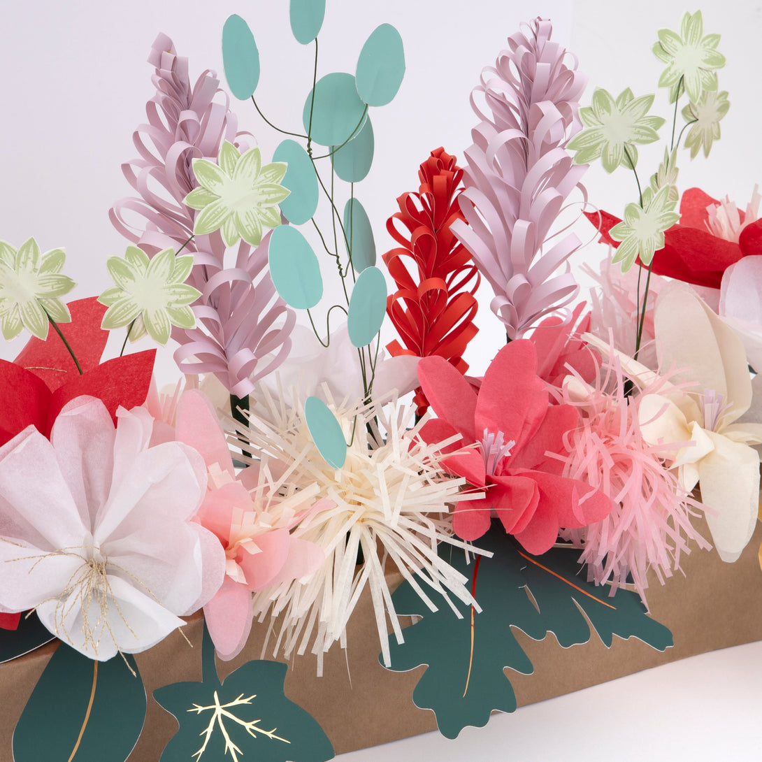 This Christmas table decoration is crafted from tissue paper flowers and foil topped paper leaves for a special look.