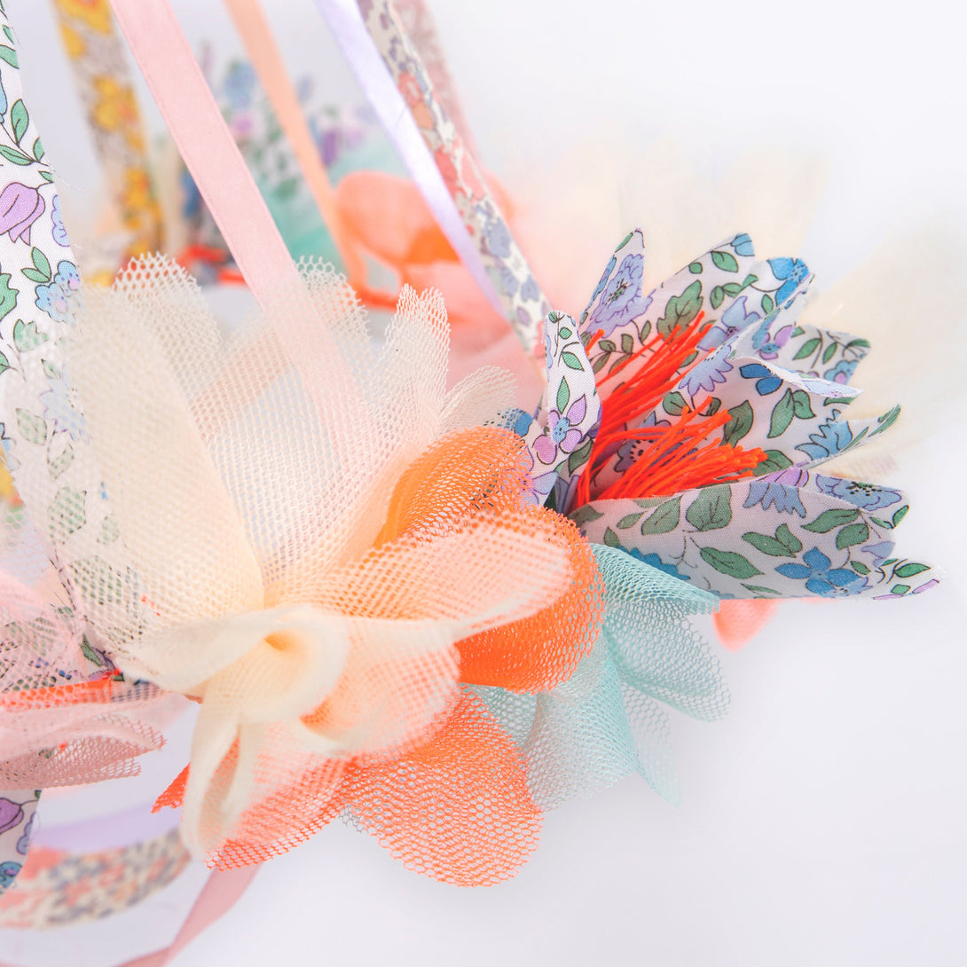 This hanging flower decoration is made from colorful fabric with streamers.