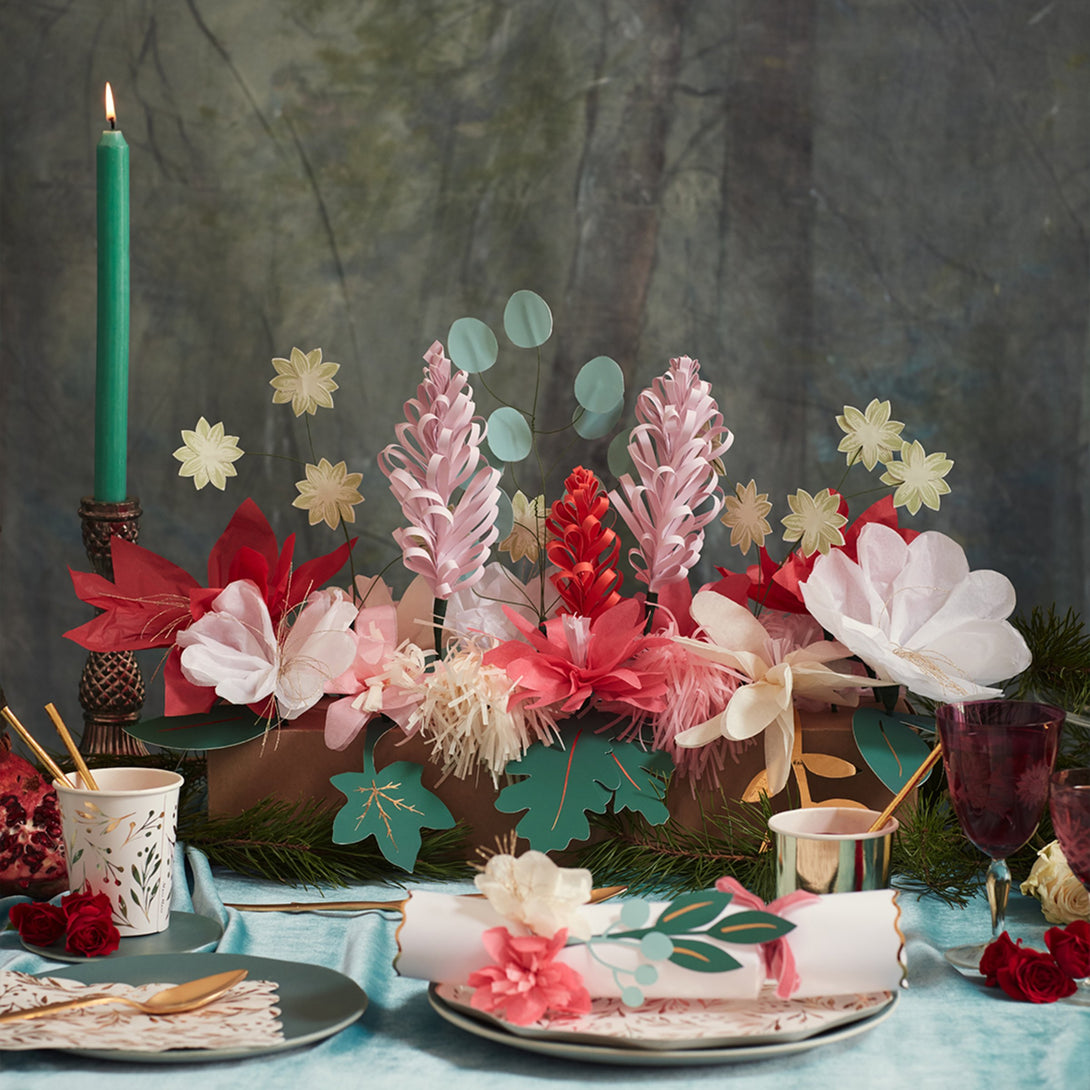 This Christmas table decoration is crafted from tissue paper flowers and foil topped paper leaves for a special look.