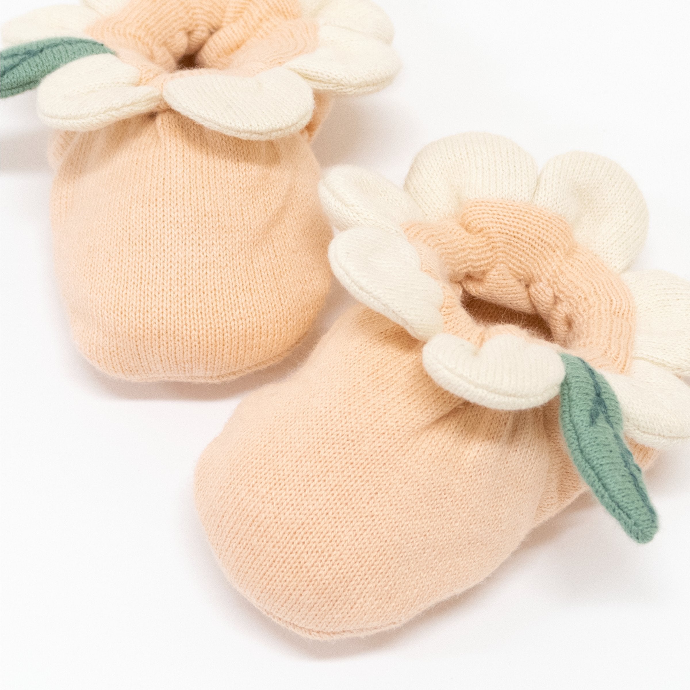 Adorable organic cotton baby clothes and baby rattle with floral details.